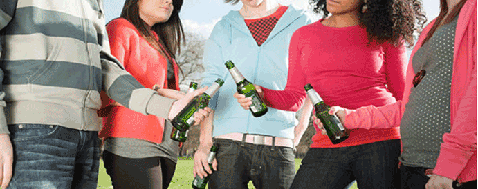 Young people holding beer bottles