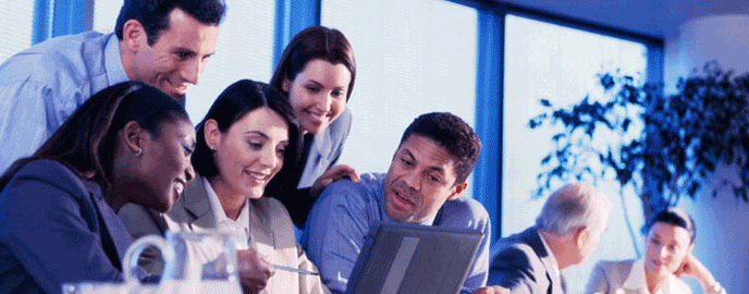 Group of adults gathered around a computer looking at the screen