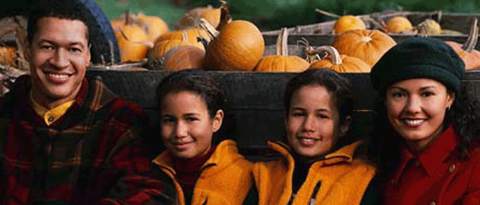 Mom, dad and two kids in a pumpkin patch