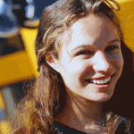 A teenage girl in front of a school bus