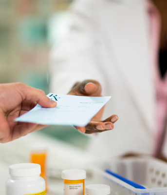 A person handing a prescription to treat chlamydia to the pharmacist