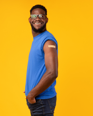 A young man with a bandaid on his arm from a recent vaccine