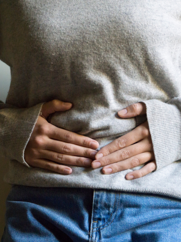 A woman holds her abdomen