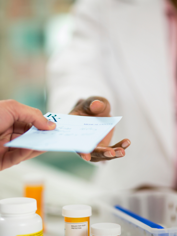 A person handing a prescription to treat chlamydia to the pharmacist